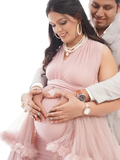 A close-up shot capturing the love between the couple as they form a heart with their hands on the baby bump. It's a classic and sweet pose for any maternity session.