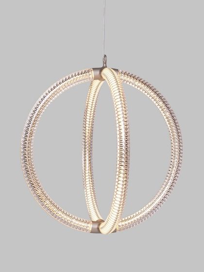 A studio shot of the Luminora pendant, highlighting the intricate, V-shaped diamond pattern on its surface. This detail shows the complexity and elegance that is achieved through its seemingly simple circular form.