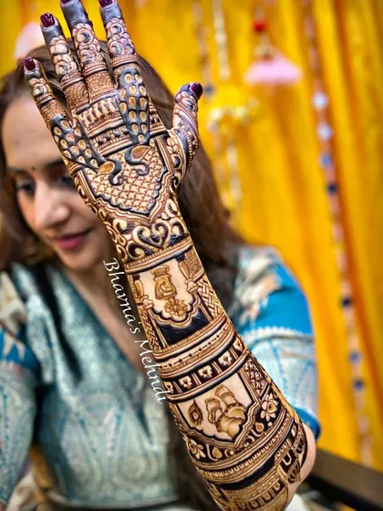 A side view of the Krishna-themed bridal mehndi, highlighting the intricate details and figures that wrap around the arm.