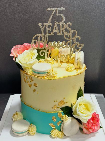 Celebrating 75 blessed years with this elegant cake. It features a two-tone design with gold leaf, fresh flowers, and macarons, proving that milestone birthdays can be incredibly stylish.