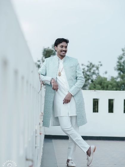A full-length shot of the groom in a stylish sherwani, looking relaxed and happy.
