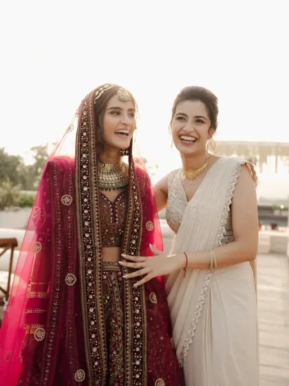 A candid moment of laughter between the bride and her sister, their genuine joy lighting up the frame.