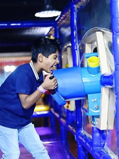 A boy having a blast with the ball cannon, a favorite for kids who love interactive and high-energy games.