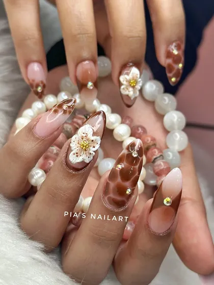 This custom set was inspired by the client's beautiful beaded bracelet. It features a brown tortoise shell design, ombre, and 3D sculpted flowers with rhinestone centers.