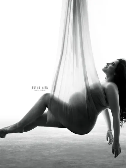 A creative and unique aerial shot. Suspended in soft fabric, this black and white image is a true work of art, symbolizing the feeling of being lifted and transformed by motherhood.