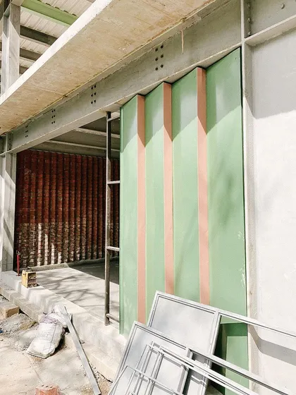 Detail of wall paneling being installed, showing the combination of different materials and colors.