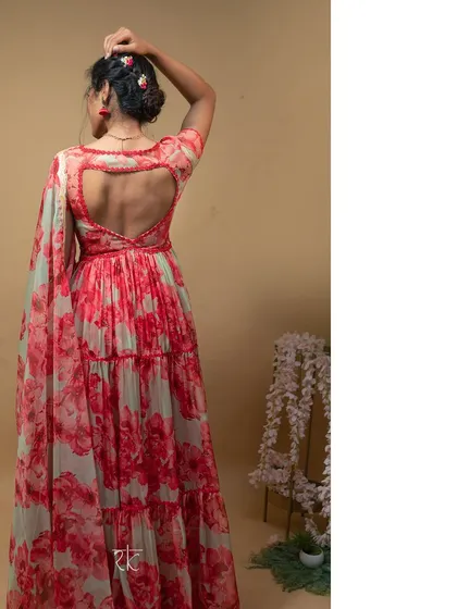The back of the red floral gown features a charming heart-shaped cutout, adding a playful and romantic detail to the elegant design.