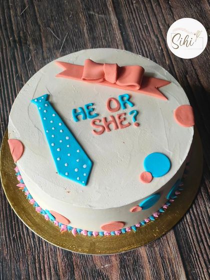 Simple, sharp, and soulful. This is another take on the "He or She?" gender reveal cake, with a clean design featuring a fondant bow and tie in pink and blue.