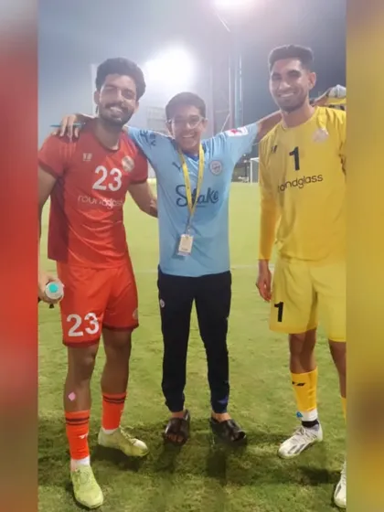 An academy player gets a photo with two professional players after a Reliance Foundation Development League match.
