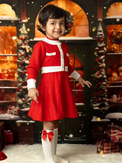 A full-length portrait of a girl in her beautiful Christmas outfit, standing in our winter wonderland studio setup.