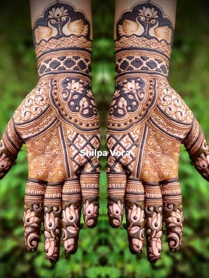 A grand, symmetrical design with peacocks at the wrist and intricate floral and geometric patterns covering the hands.