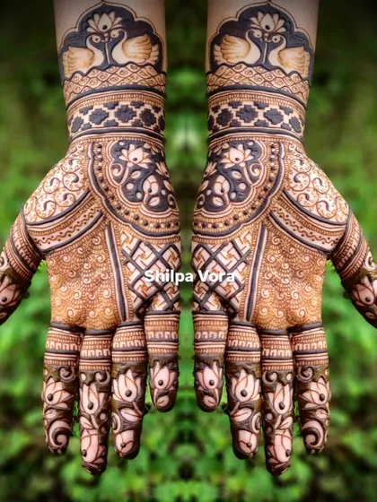 A grand, symmetrical design with peacocks at the wrist and intricate floral and geometric patterns covering the hands.