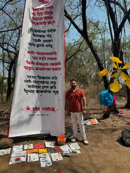 Standing next to the fully displayed calligraphy roll at the Gulmohar Day festival in Satara.