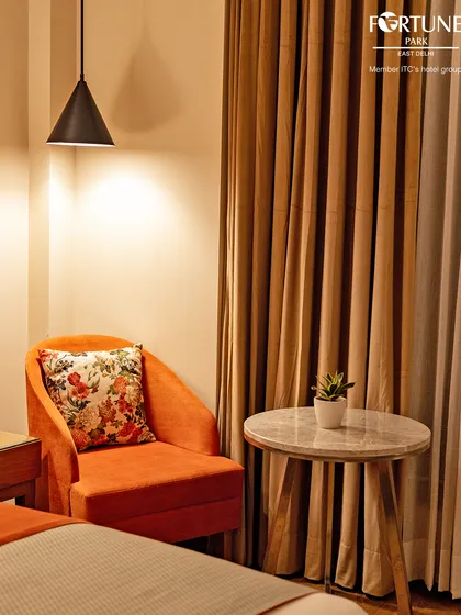 A cosy reading corner in our luxury room, complete with a comfortable armchair and a side table. It's the perfect spot to unwind with a book.
