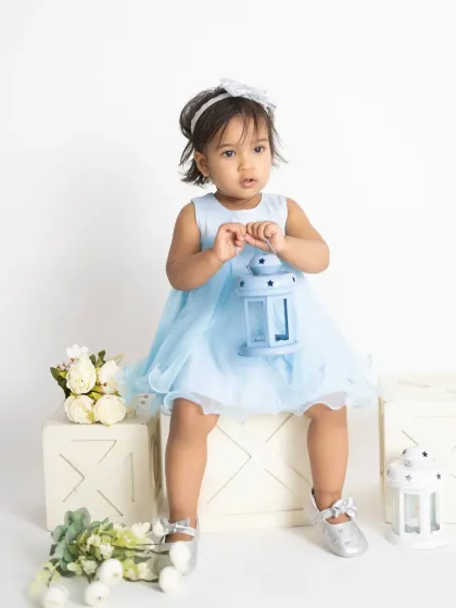 This little princess is holding a lantern prop, her curiosity captured perfectly. Simple props can help engage a toddler during their session.