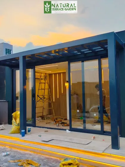 A work-in-progress shot of the terrace room, showing the structural frame and the installation of the interior wooden paneling and lighting.