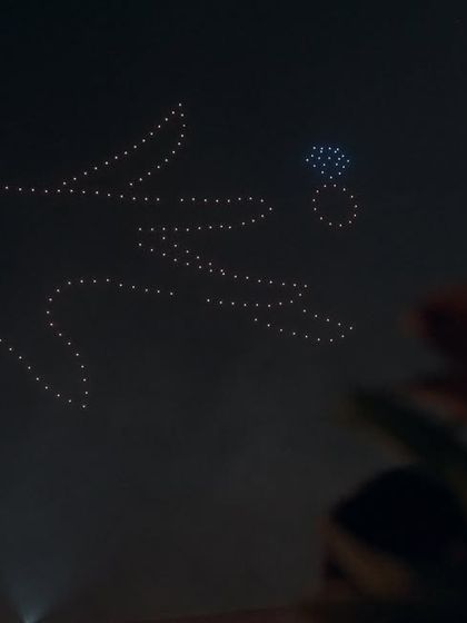 The moment of "yes," recreated on a celestial scale. This drone formation of a hand placing a ring on a finger is a powerful and creative way to celebrate an engagement or proposal.
