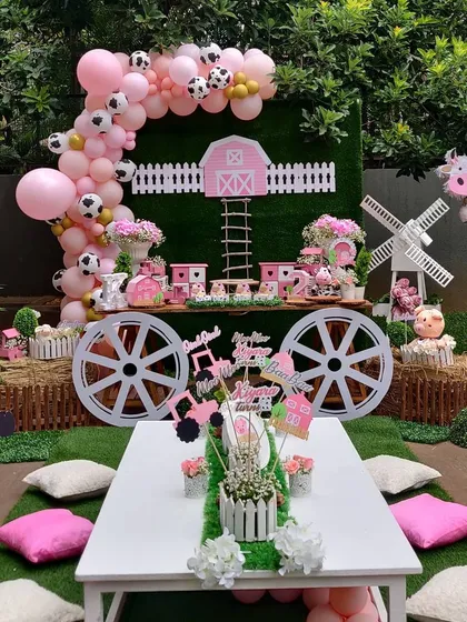 Welcome to our charming pink barnyard. This party theme is perfect for little animal lovers, featuring a complete setup with a custom dessert cart, themed cutouts, a low seating arrangement for kids, and a beautiful balloon arch with cow-print accents.