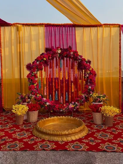 A closer look at the rooftop ceremony backdrop, featuring a circular frame decorated with flowers and tassels.