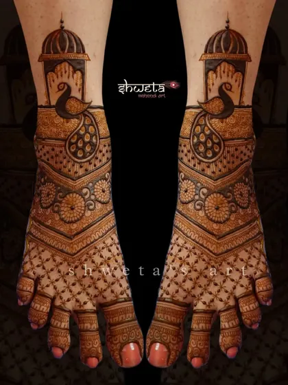 A beautiful peacock-themed leg mehendi design. The pattern features a large peacock under a dome, with intricate jaali work covering the rest of the foot for a traditional look.