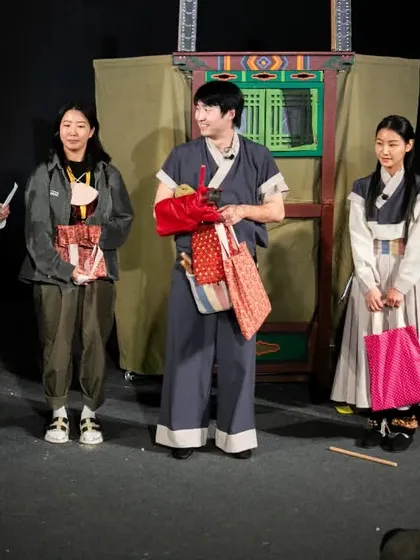 The cast of 'Hong Dongji & Isimi' from Korea receives gifts on stage after their performance. We value the cultural exchange our festival fosters.