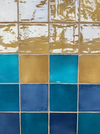 A close-up of some of the glazed ceramic tiles selected for Mina Creamery. The rich blues, yellows, and whites will be used to create a playful yet timeless energy in the ice cream bar.