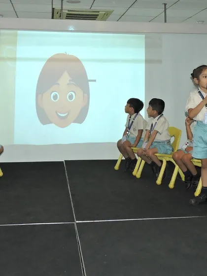 A young learner presents her answer during a language competition. These events are designed to sharpen listening and spelling skills in a supportive and encouraging environment.