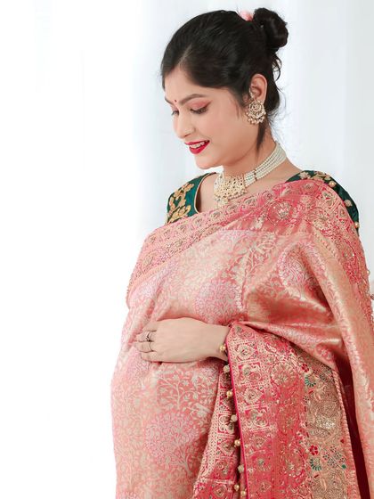 A serene side-profile portrait, highlighting the beautiful drape of the saree over the baby bump. The soft lighting adds to the peaceful mood.