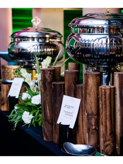 A modern buffet line featuring sleek, silver chafing dishes set against a rustic wooden fence design. This demonstrates our ability to blend different stylistic elements for a unique look.
