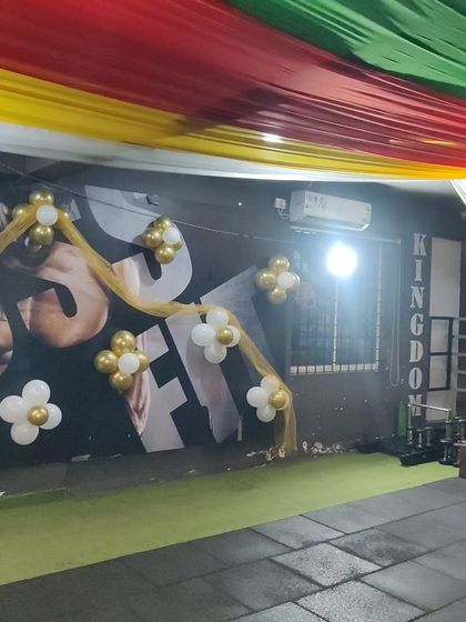 A closer look at the wall decor for the gym event. I used simple gold and white balloon flowers with tulle fabric to decorate the walls, matching the festive theme while keeping the space open.