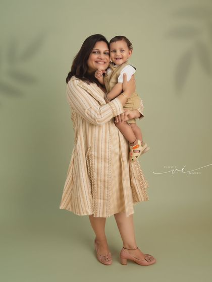 A sweet and simple mother-son portrait. The mother holds her son close, both sharing a gentle smile, capturing the warmth and love between them.