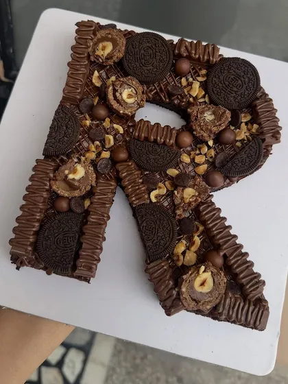 Personalization at its most delicious. This is my Monogram Brownie Cake, a fudgy Belgian chocolate brownie loaded with Ferrero Rocher, Oreos, and nuts, shaped into the initial 'R'.