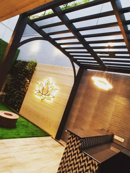 A view of the backyard project from inside the pergola, looking out at the illuminated lotus art on the wall.