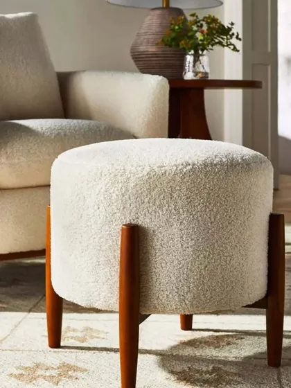This comfortable pouf with solid wood legs is a versatile piece. It can be used as a footrest, extra seating, or even a small side table.
