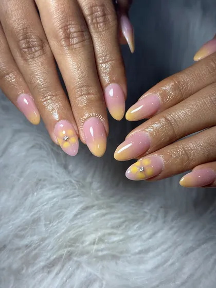 A soft and sunny design with a pink and yellow ombre base and a delicate, hand-painted flower accent.