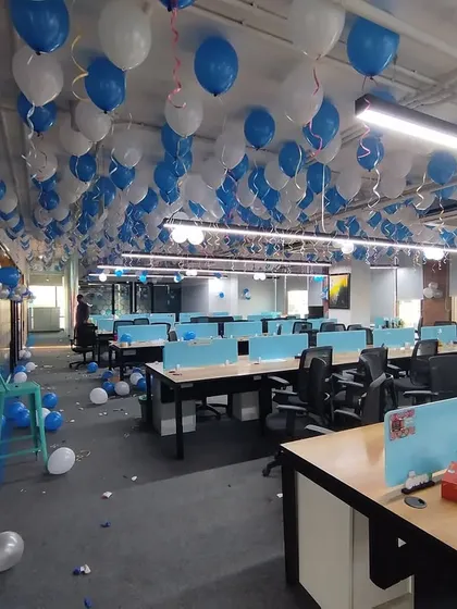 This is a wide view of a full office floor decorated for a company anniversary. I filled the entire ceiling with hundreds of blue and white balloons to completely transform the workspace and make the celebration feel immersive for the whole team.