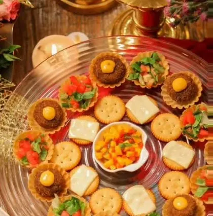 A beautiful party platter featuring crackers with cheese, savory tarts, and fresh salsa. This shows the variety I can offer for a canapé station.