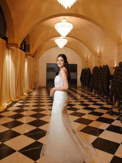 This elegant half-up, half-down hairstyle was designed for a cocktail party. The front is kept sleek and away from the face, while the back flows into soft waves, pairing perfectly with a modern bridal gown.