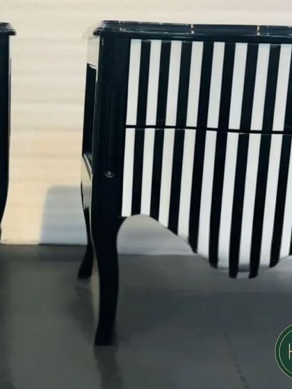 A pair of the black-and-white striped chests, showing their dramatic and eye-catching design. We craft experiences of luxury, comfort, and elegance.