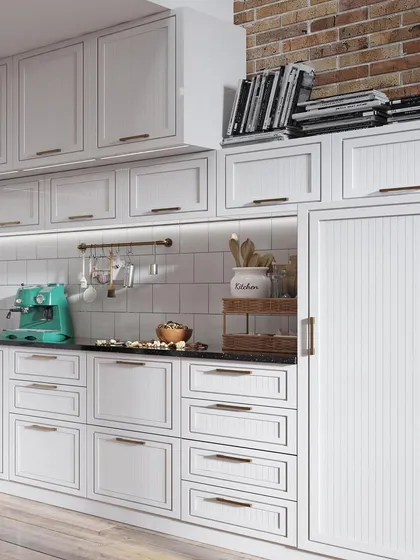 This kitchen showcases a classic aesthetic with a modern touch. The all-white shaker-style cabinets provide ample storage and a clean look, contrasted beautifully by the rustic exposed brick wall above.