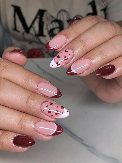 A cute and romantic design featuring a deep red French tip and accent nails with a pattern of tiny red hearts.