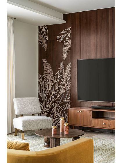 This shot highlights the custom furniture in the informal living room, including a low-profile armchair and a carved wooden coffee table. The hand-painted mural on the wood paneling adds a unique, artistic touch that is central to our design philosophy.