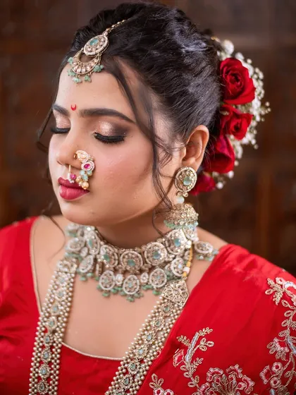 A beautiful profile shot showcasing the complete Maharashtrian bridal look, including the intricate hairstyle with fresh roses.