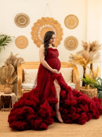 A confident and elegant pose showing off the high slit and dramatic ruffles of the red gown.