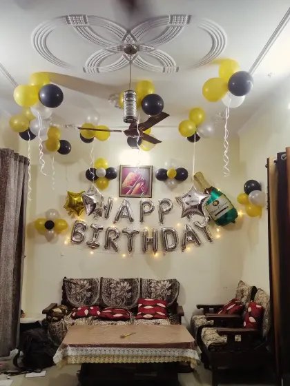 A classic birthday decoration at home with 'Happy Birthday' foil letters and balloons on the wall and ceiling.
