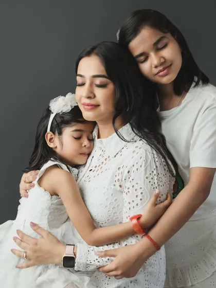 A heartfelt studio portrait capturing the tender embrace between a mother and her two daughters. These are the quiet, emotional moments we strive to preserve forever in our mother-daughter photoshoots.