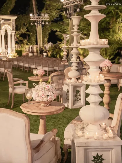 The guest seating area for the Birla House wedding, featuring elegant lounge furniture, floral centerpieces, and sculptural candle stands.