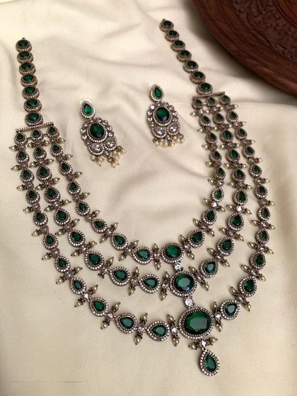 A three-layered necklace set with an antique silver finish. This long necklace is perfect for creating a layered, bohemian look and is available in green, blue, and red stones.