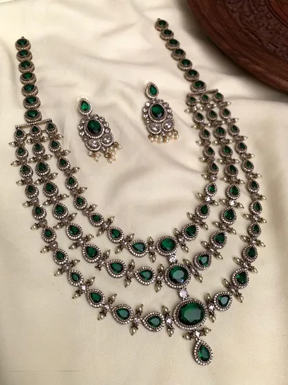 A three-layered necklace with an antique finish and green stones, offering a vintage vibe.