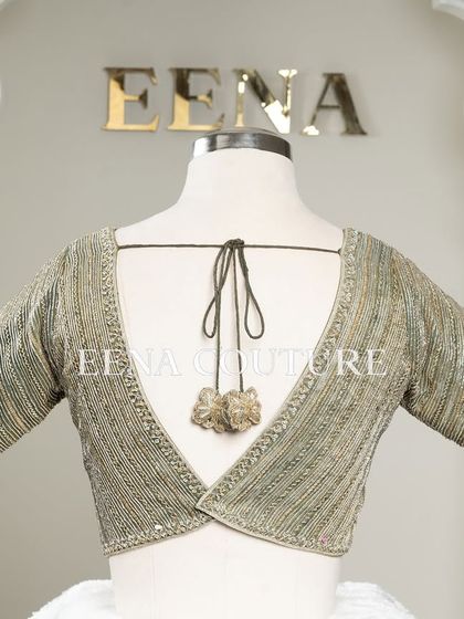 I designed this sage green raw silk blouse with geometric handwork for a timeless yet modern feel. The linear beadwork is complemented by custom floral tassels, making it a versatile piece for any occasion.